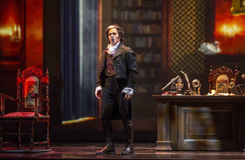 Baritone Andrew Garland as the compulsive, domineering book collector, Baron Otto von Schott, in the library of his ancestral fortress.